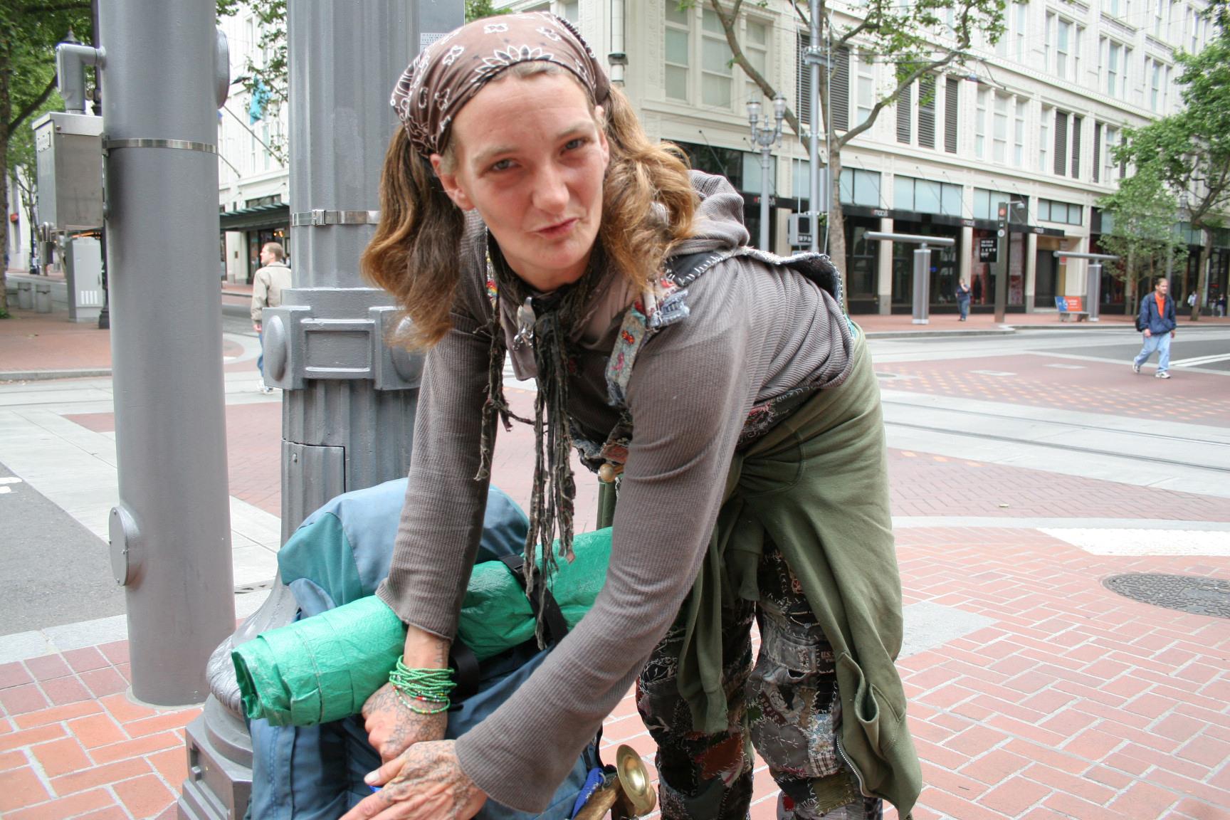 Abby packs up her gear after performing on the corner of SW 5th and SW Morrison in downtown Portland, Oregon. Part of Artful Journey of Life and Redefining Perceptions of Homeless and Poverty by Mary Anne Funk
