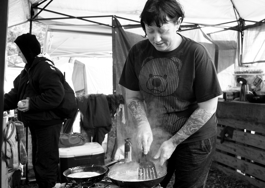 Grace cleans a pan, in the community kitchen, after preparing eggs for other members of the Hazelnut Grove Community.