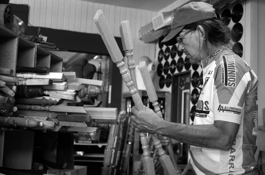 Mark Funk looks through wooden balusters at ReClaim It in North Portland, Oregon on N. Killingsworth. Design by Mark Funk. Photo by Mary Anne Funk