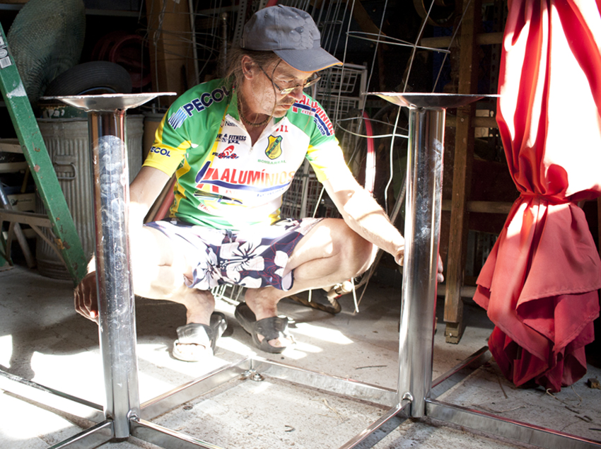 Mark Funk looks over the metal leg stands that he has decided on for the tiled game tables. Design by Mark Funk. Photo by Mary Anne Funk